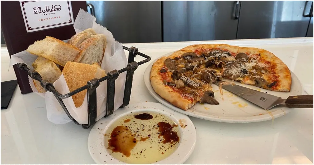 I love shareable dishes like this pizza at Il Mulino at Disney's Swan resort sitting at the bar with my spouse enjoy the bread service as well.