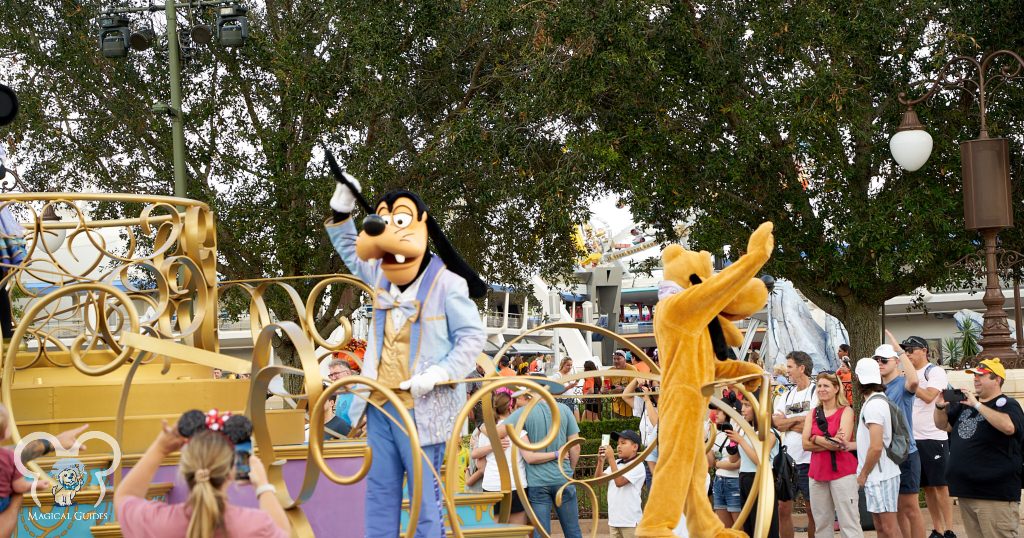 Goofy leading the parade float with Mickey's dog Pluto waving to the crowds in Magic Kingdom.