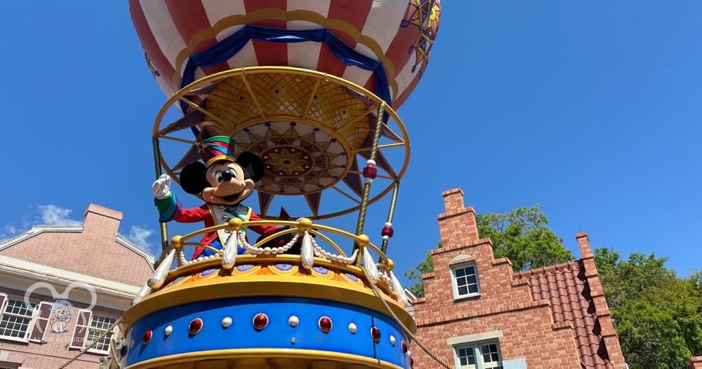 Mickey Mouse waving to guests from a parade float in the Festival of Fantasy Parade in Magic Kingdom.