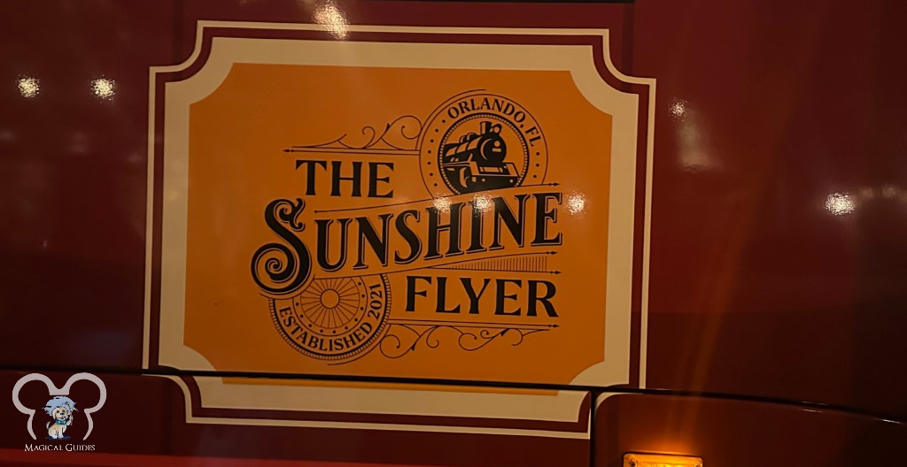The Sunshine Flyer sign on the side of the motor coach.