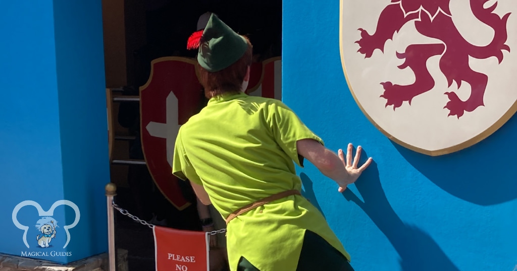 Peter Pan playing in Magic Kingdom outside the Peter Pan ride. Peter was hiding behind the wall and sneaking up on guests waiting in line and waving to them.