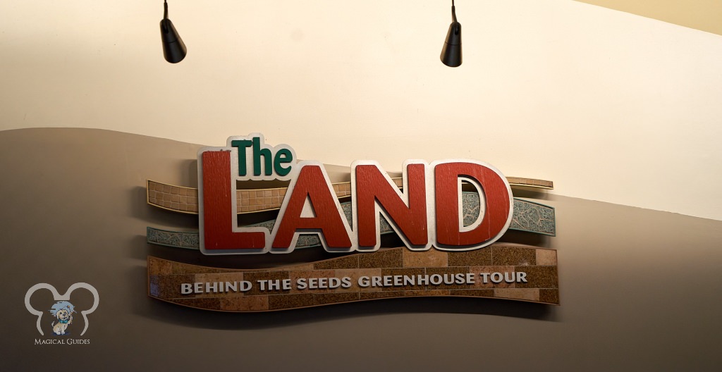 Behind the Seeds Greenhouse Tour sign located right beside Living with the Land attraction.