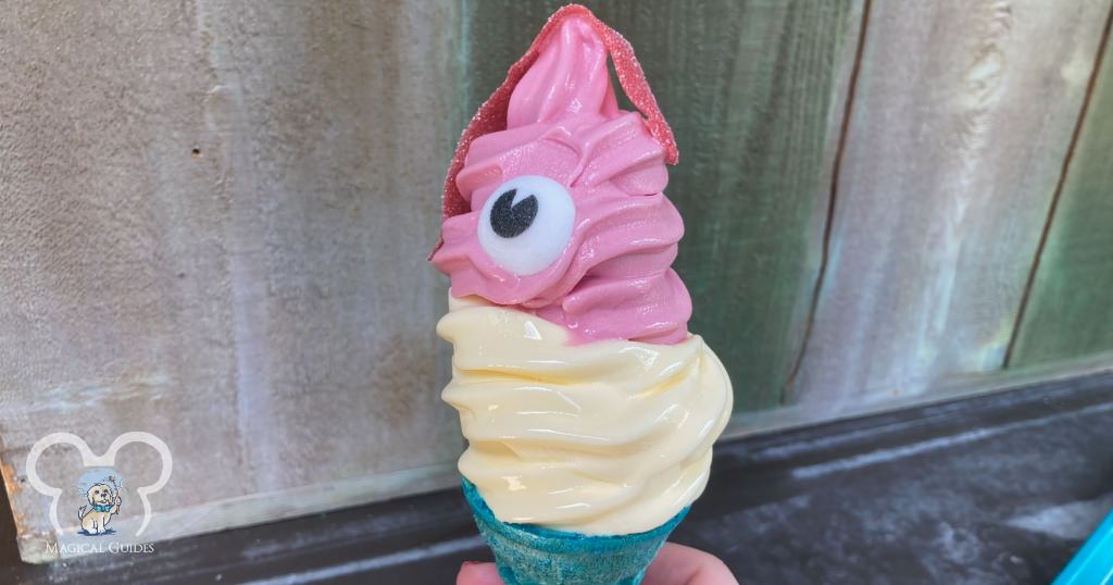 Hei Hei Cone at Typhoon Lagoon. Dole Whip® Raspberry and Dole Whip® Pineapple with a sour candy piece and sugar eye in a blue cone.