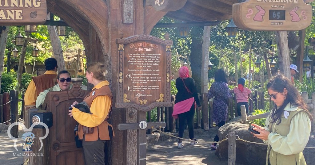 Cast members standing by to test younger guests to see if they meet the height requirements for Seven Dwarves Mine Train ride in Magic Kingdom.