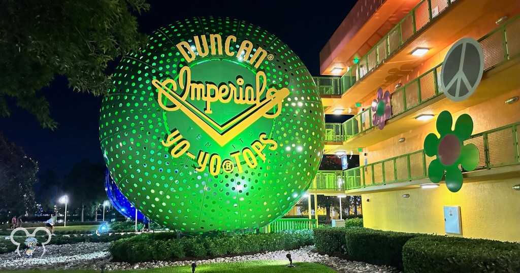 Green Yo-Yo on the 60s building at Disney's Pop Century Resort lit up at nighttime. This is a beautiful resort at night.