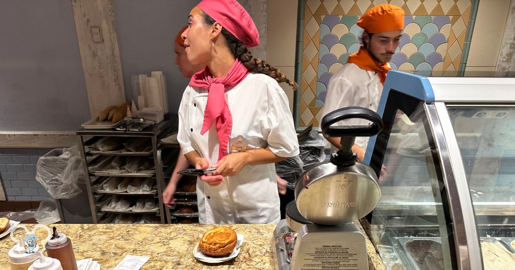 Watching the cast member make my Disney treat while asking for additional sauce as it was quite busy inside the France Pavilion.